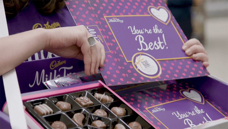 Boxes of personalised Cadbury chocolate with a QR code.